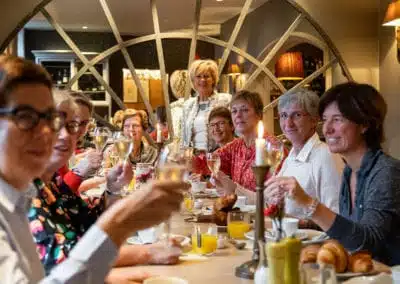 Groep gasten genietend van een feestelijk ontbijt in het restaurant van Hotel Auberge l'Entrecôte.