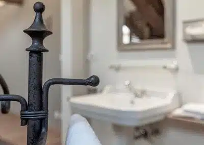 Detail van een handdoekhouder en wastafel in de badkamer van Hotel Auberge l'Entrecôte.